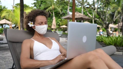 Remote working at the beach during corona virus. Caucasian Female in a face mask Video stock 153293081