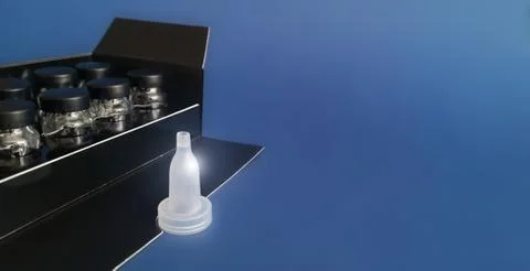Removable dropper in front of bottles in black box on classic blue background Foto stock