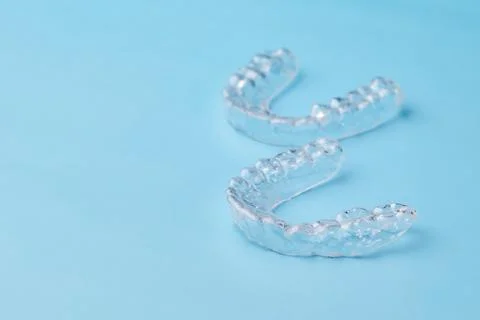 Removable teeth aligners on the blue background with copy space. Orthodontic Stock Photos