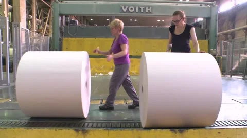 Removal of finished paper from the paper machine by workshop workers. Stockbeeldmateriaal 270747321