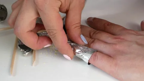 Removal of shellac with nails,a bamboo stick.Makes herself a manicure. 스톡 동영상 133218528