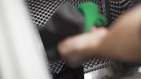 Removal of washed clothes from the washing machine with the opening on the top Stock Footage 145717647