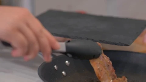 Remove the bacon from the pan on a black stone Stock Footage 111271571