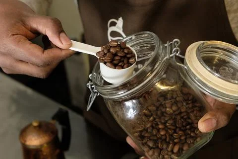 Remove the coffee beans from the jar with a measuring spoon Foto stock