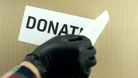 Remove Donations label sticker from a Donation cardboard Box closeup Stock Footage 142667381
