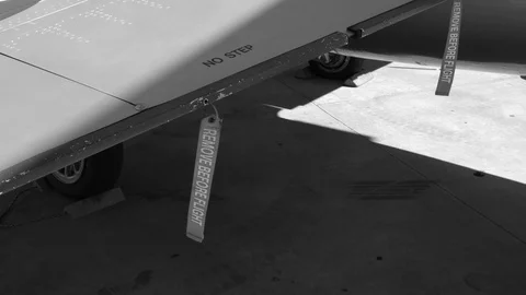 REMOVE BEFORE FLIGHT red ribbon tags on wing of military fighter jet. Stock Footage 101620242