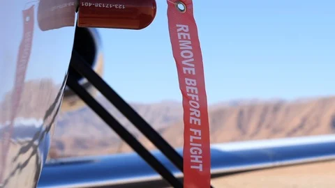 A "Remove Before Flight" tag attached to an aircraft slowly blowing in the Stock Footage 102762864