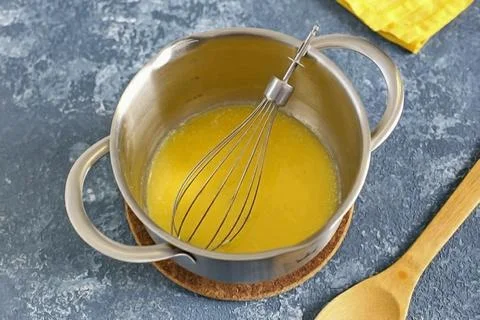 Remove from heat and immediately pour in butter in a thin stream, working wel Stock Photos