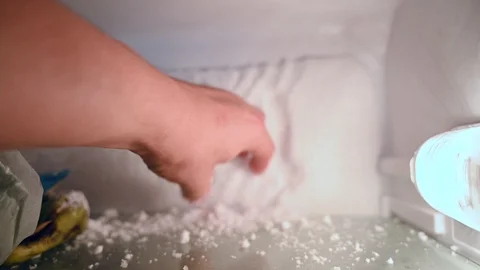 Remove the ice condensation from the fridge with  hand Stock Footage 112827709