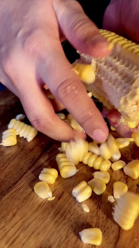 Remove kernels from the cob of an ear of sweet corn. Removing kernels corn. Stock Footage 287437469