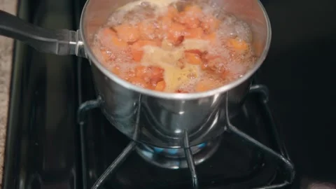 Remove lid from carrots boiling Stock Footage 284180098