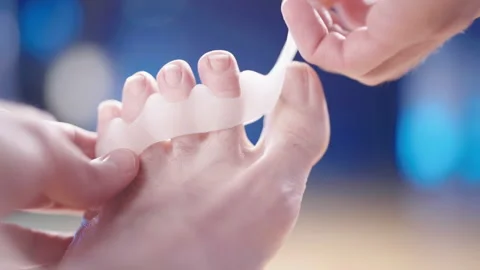 Remove medical silicone toe corrector spreader between toes close-up 4K Stock Footage 170117594