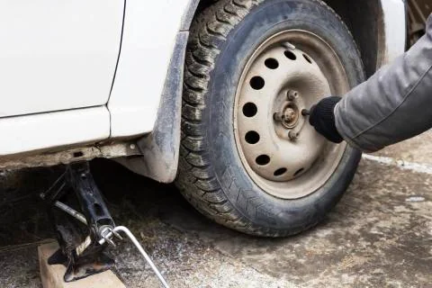Remove the nut the wheel of a car Stock Photos