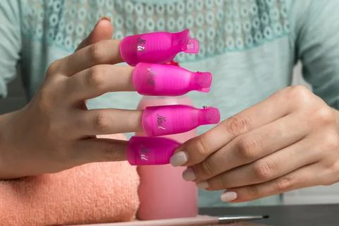 Remove the old gel polish using nail clips. The girl does her own manicure. B Photos