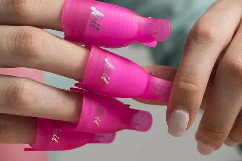 Remove the old gel polish using nail clips. The girl does her own manicure. B Foto stock