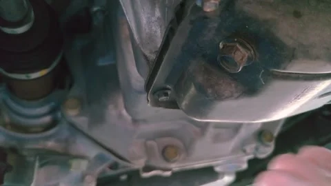 Remove old oil from the drain bolt to change the oil FIX Stock Footage 297125021