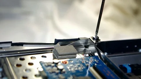 Remove screws in a digital device using tweezers Stock Footage 70303758