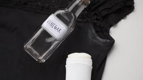 Remove white antiperspirant stains from a black T-shirt using vinegar. Stock Footage 340147773