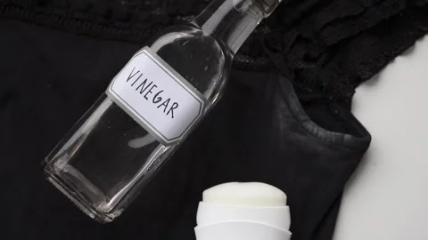 Remove white antiperspirant stains from a black T-shirt using vinegar. Stock Footage 340147816