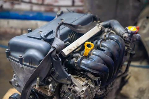 Removed car engine with intake manifold and alternator in auto repair workshop Foto stock