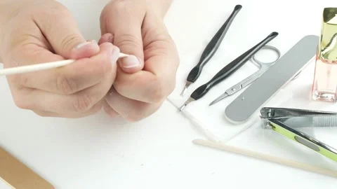 Removes the cuticle sharpened bamboo stick.Makes herself a manicure. Video stock 136740121