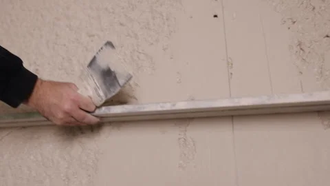 Removes excess plaster, Plaster leveling, Surface smoothing Stock Footage 330013492