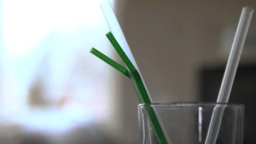 Removing and placing plastic straws into a glass Stock Footage 85825668