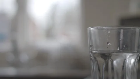 Removing and placing plastic straws into a glass of water Stock Footage 85827942