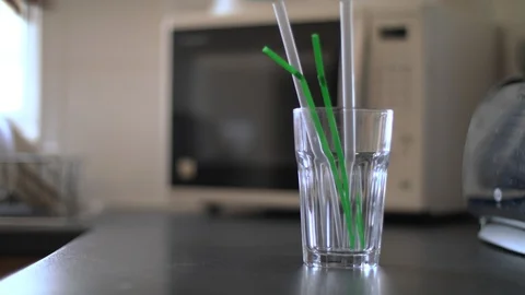 Removing and replacing plastic straws in an empty glass Stock Footage 85825885