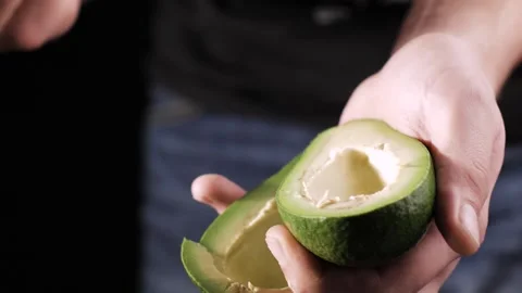 Removing avocado pit with a knife close-up. Video stock 148644198
