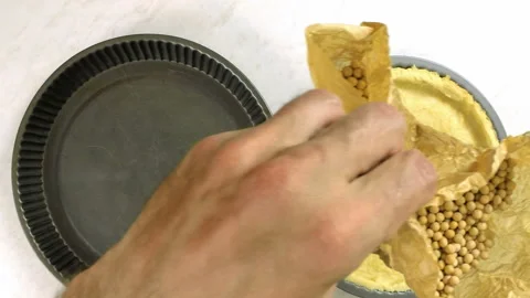 Removing baking beans from pastry case Stock Footage 100231879