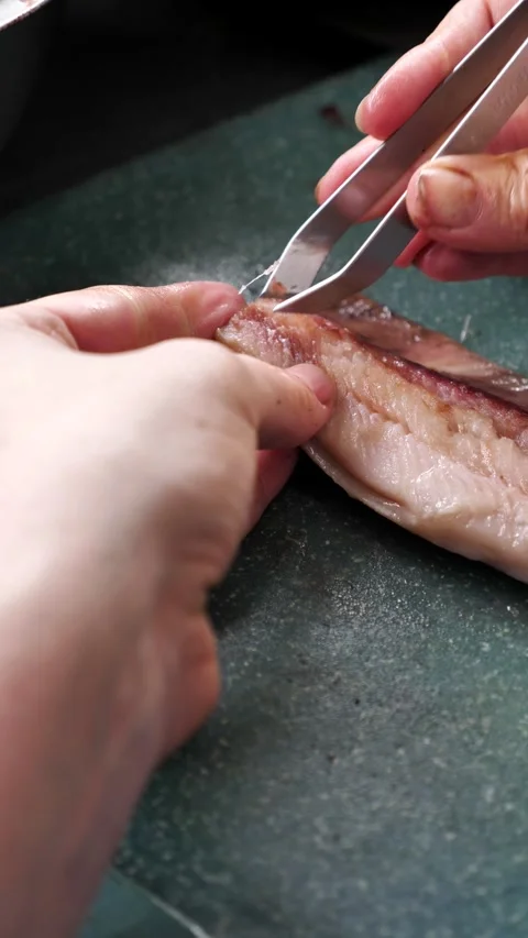 Removing belly and small bones from fish fillets in the kitchen Stock Footage 337594090