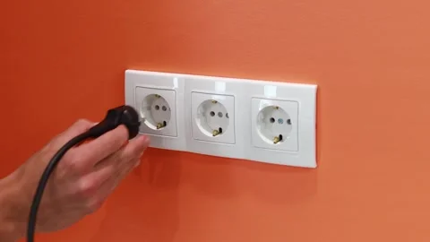 Removing Black Plug from White Electrical Outlet Stock Footage 258620958