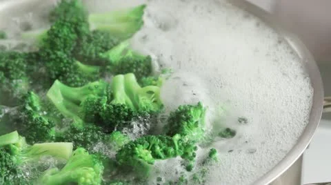 Removing broccoli florets from boiling water with a slotted spoon Stock-Footage 24665099