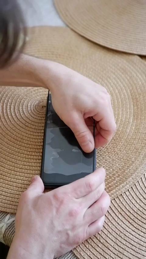 Removing a broken glass screen protector from a smartphone Stock-Footage 338008600