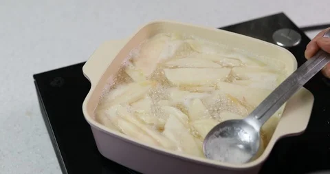 Removing bubble from boiling water with slices of peach in bowl Stock Footage 113916798
