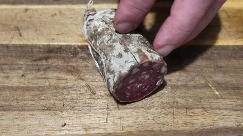 Removing casing from wild boar dry sausage Video stock 345836823