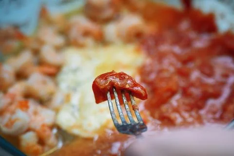 Removing a cherry tomato skin from a fork during sauce preparation for a sm.. Stock Photos
