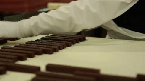 Removing chocolates from conveyer belt Video stock 77048481