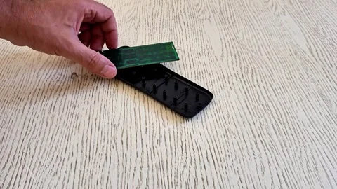 Removing the Circuit Board from a Disassembled TV Remote Control Stock Footage 340746802