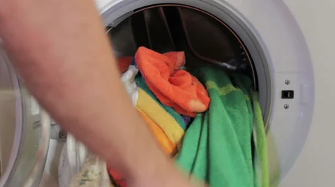 Removing clean clothes from a washing machine Stock Footage 35197000
