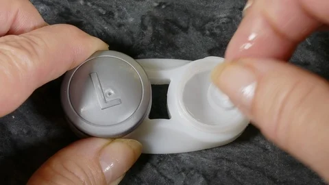 Removing a contact lens from its case. Stock Footage 119666426