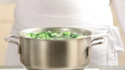 Removing cooked broccoli from a pan Stock Footage 24664698