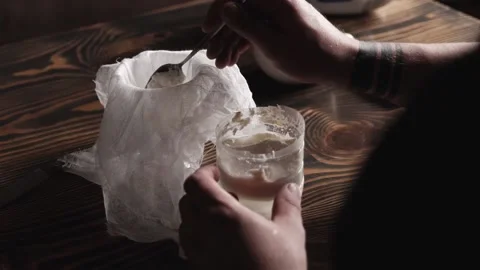 Removing cottage cheese from milk. a man skims milk with a spoon. make fermen Stock Footage 166557751