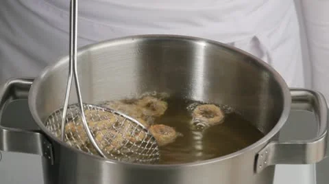 Removing deep-fried calamari from oil Stock Footage 24666145
