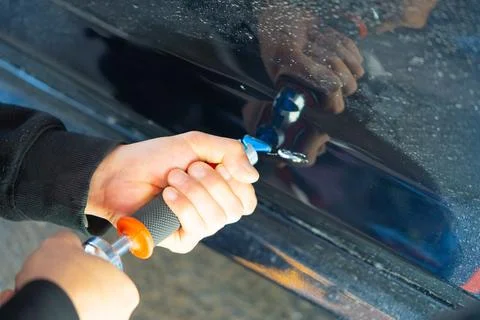Removing dents on the car. PDR technology. Car body repair without painting. Stock Photos