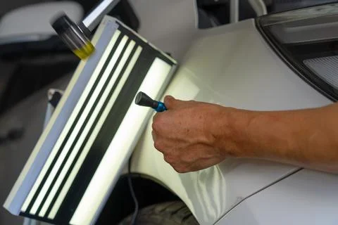 Removing dents on the car. PDR technology. Car body repair without painting. Stock Photos
