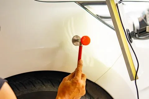 Removing dents on the car. PDR technology. Car body repair without painting. Stock Photos