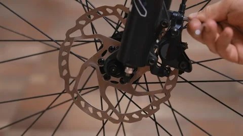 Removing a disc brake caliper from a bicycle suspension fork Stock Footage 280481963