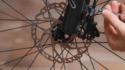 Removing a disc brake caliper from a bicycle suspension fork Video stock 280482374